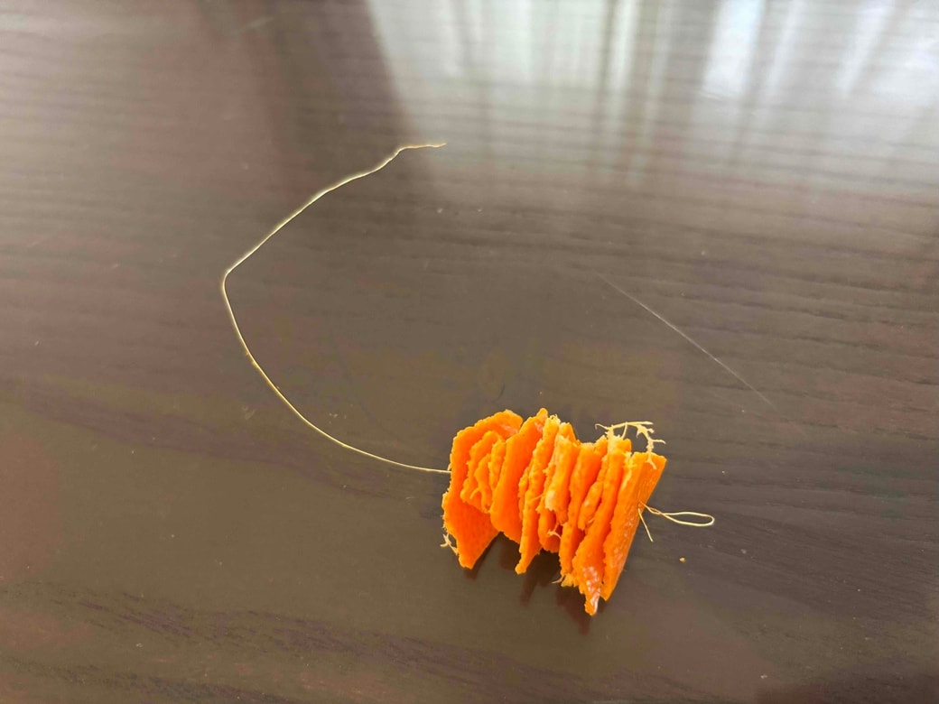 ワイヤーにみかんの皮を通しているところ