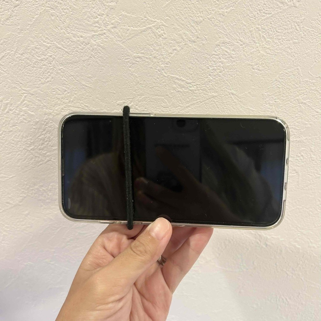 ヘアゴムにスマホを通しているところ