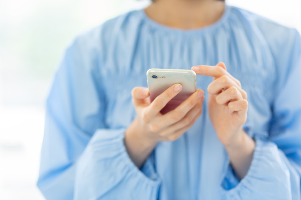 スマホでポイ活をする主婦