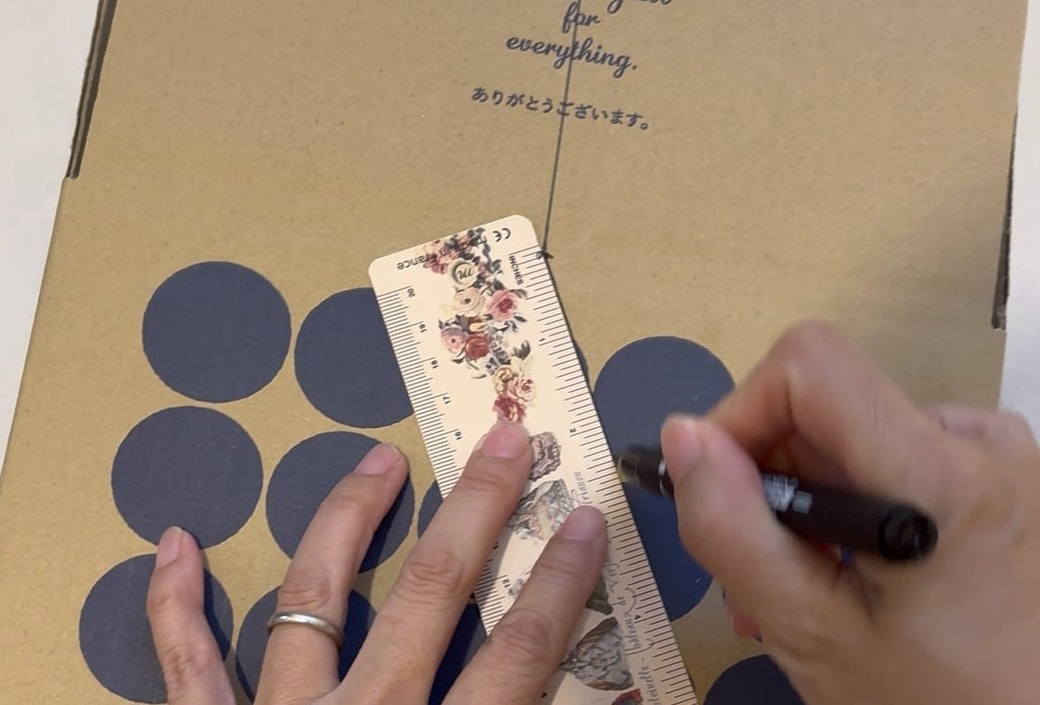 段ボールにペンで印をつける様子