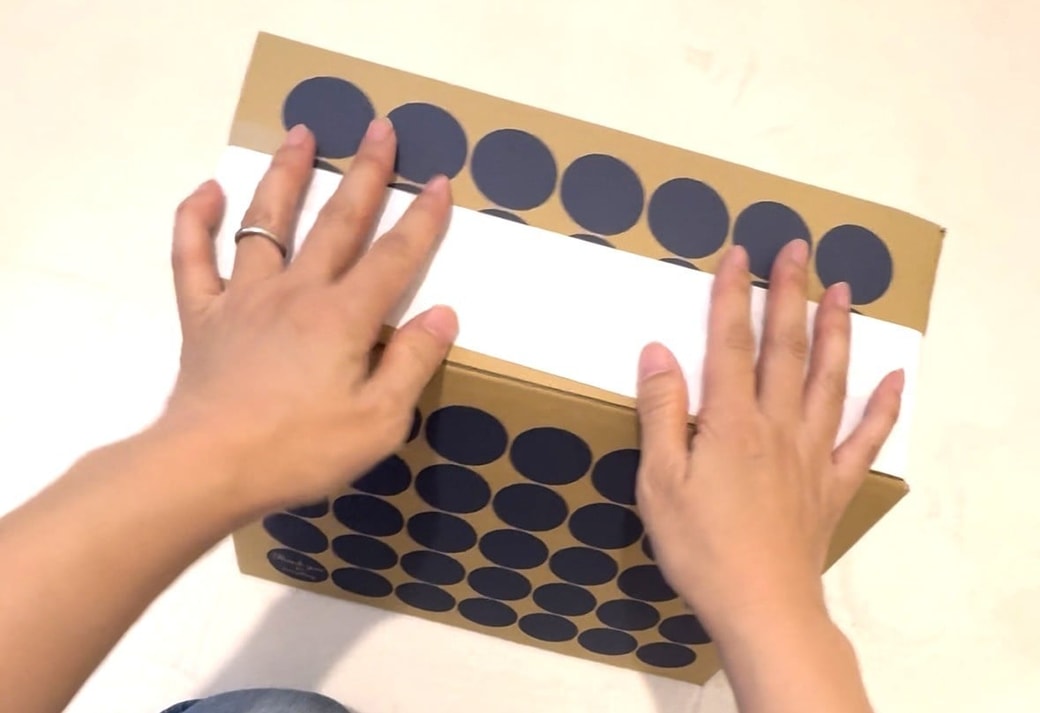 段ボール椅子の強度を確かめる様子