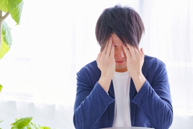 顔を覆う男性