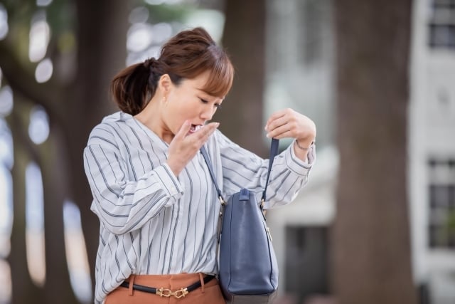 カバンの中をのぞいている女性