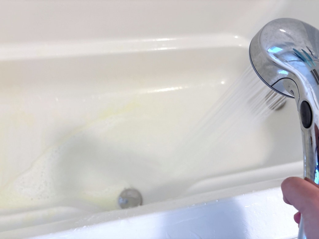 シャワーをかけて洗剤と汚れを洗い流す