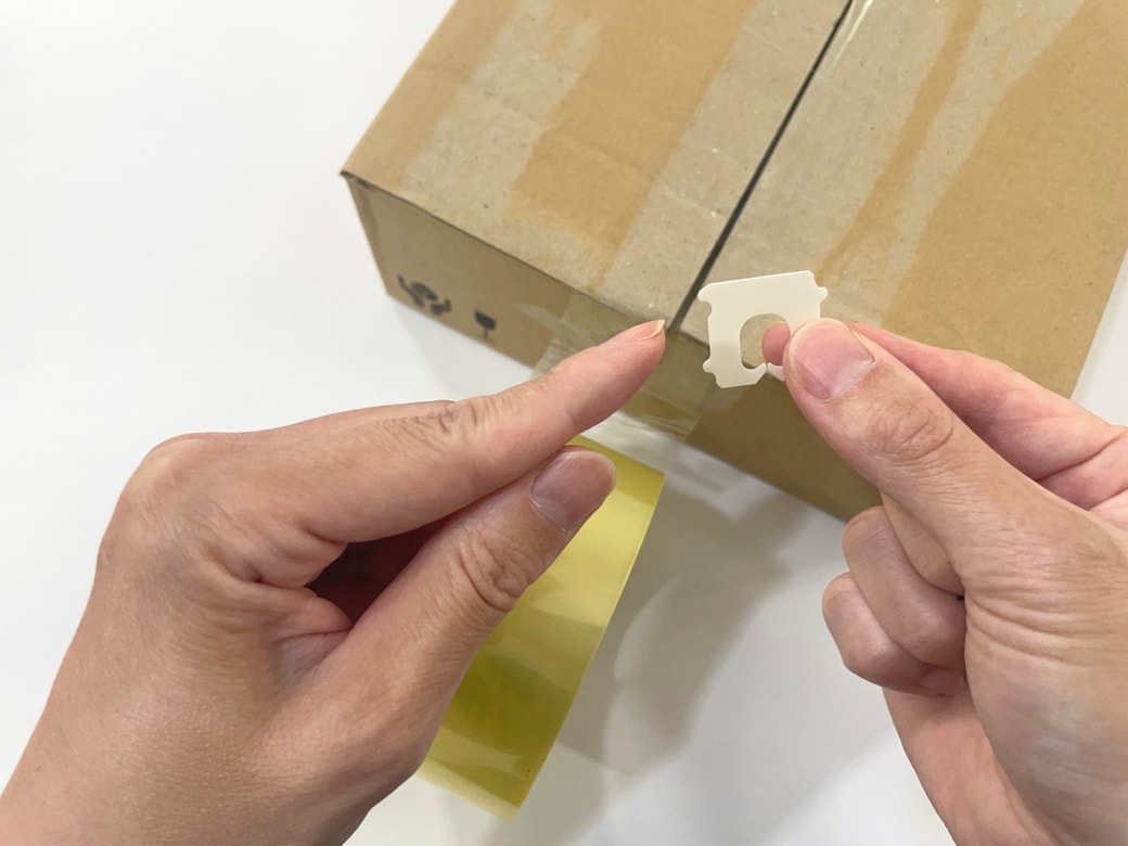留め具の角をテープに押しあてる