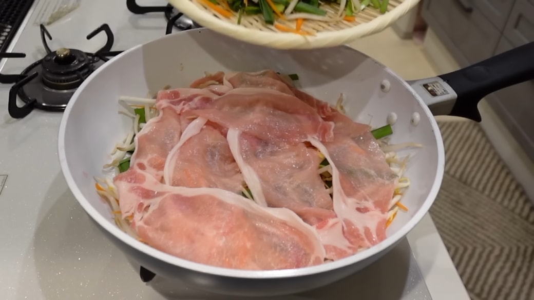 野菜や豚肉を敷き詰めたフライパン
