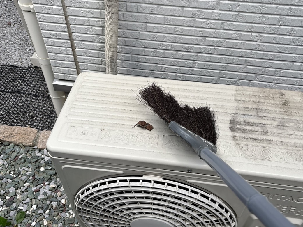 天板のゴミをほうきで取り除く