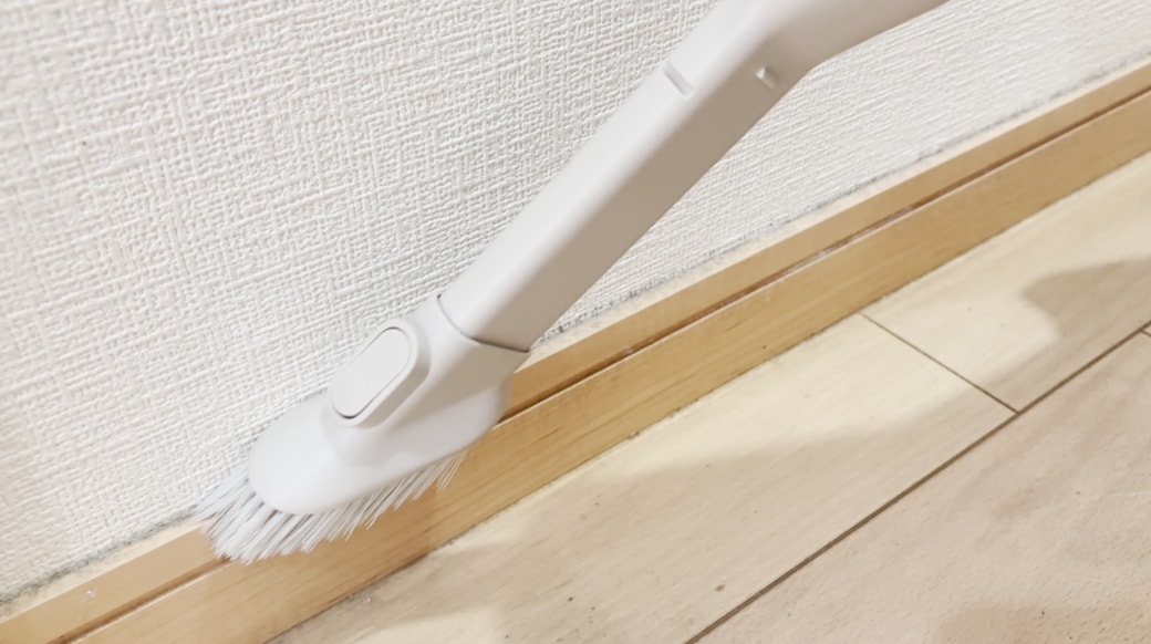 掃除機で巾木のホコリを吸い取る