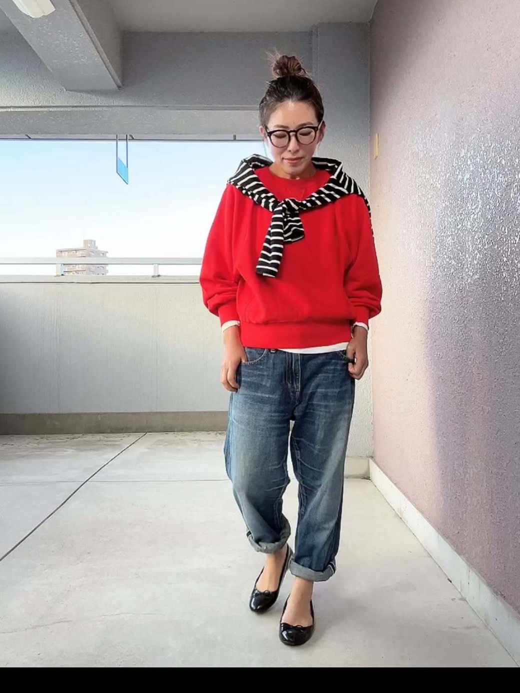 赤のスウェットトップスでメリハリの効いた着こなしに。