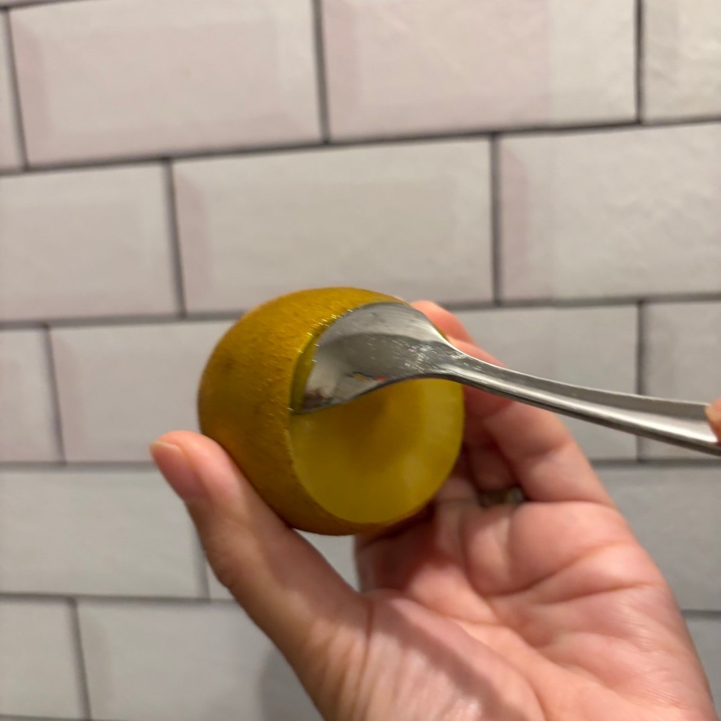 キウイにスプーンを入れているところ