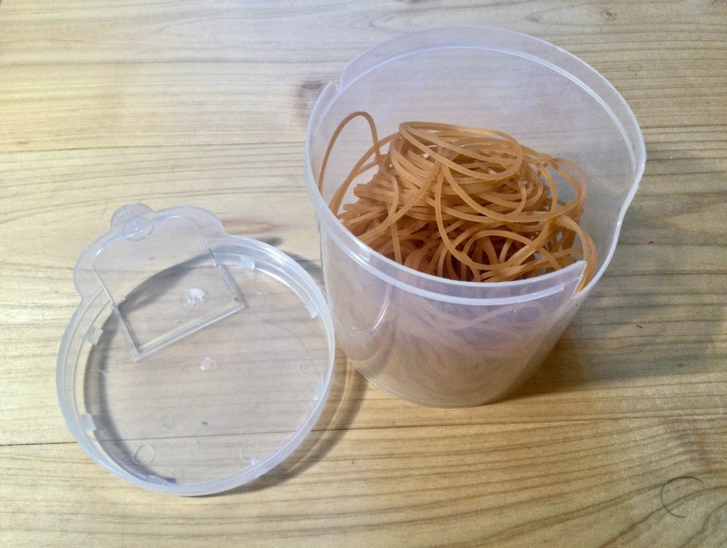 綿棒の空き容器に輪ゴムを入れる