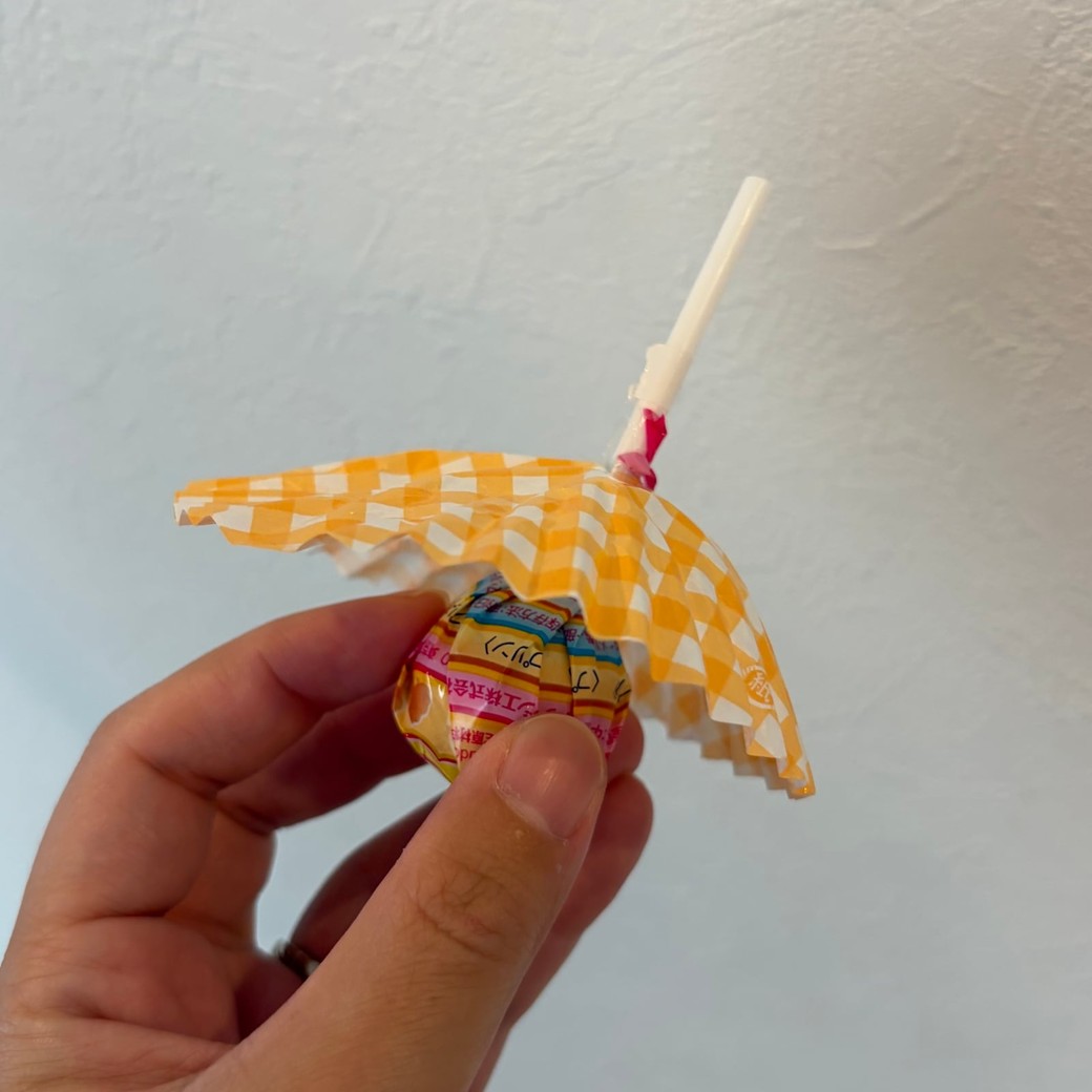 おかずカップに棒つきキャンディを刺しているところ