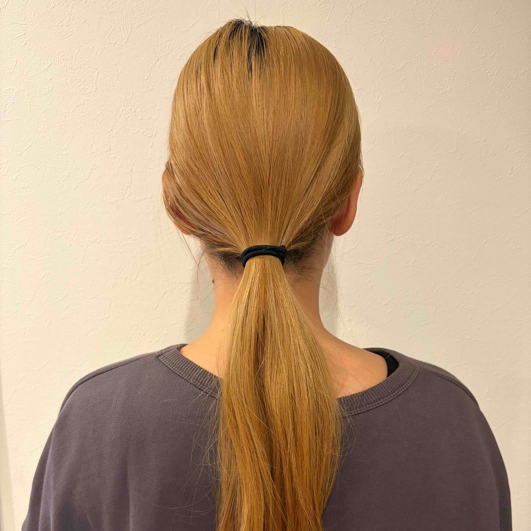 ねじったゴムを髪にかけているところ