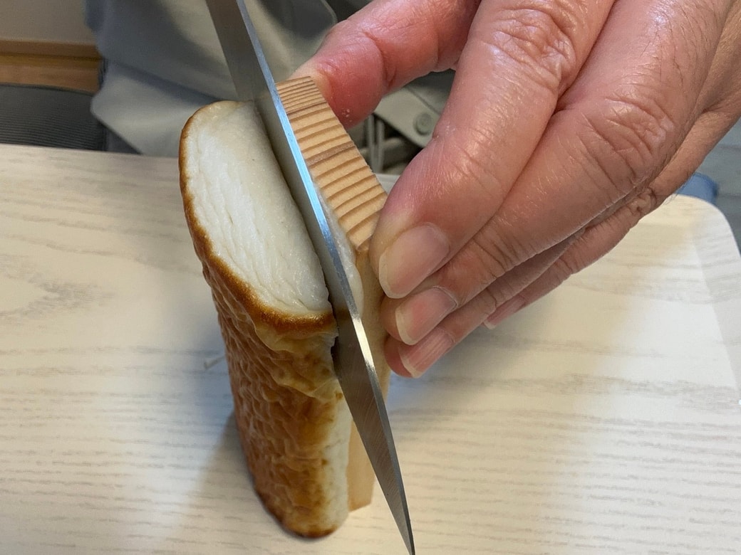 かまぼこを包丁で板からはがす