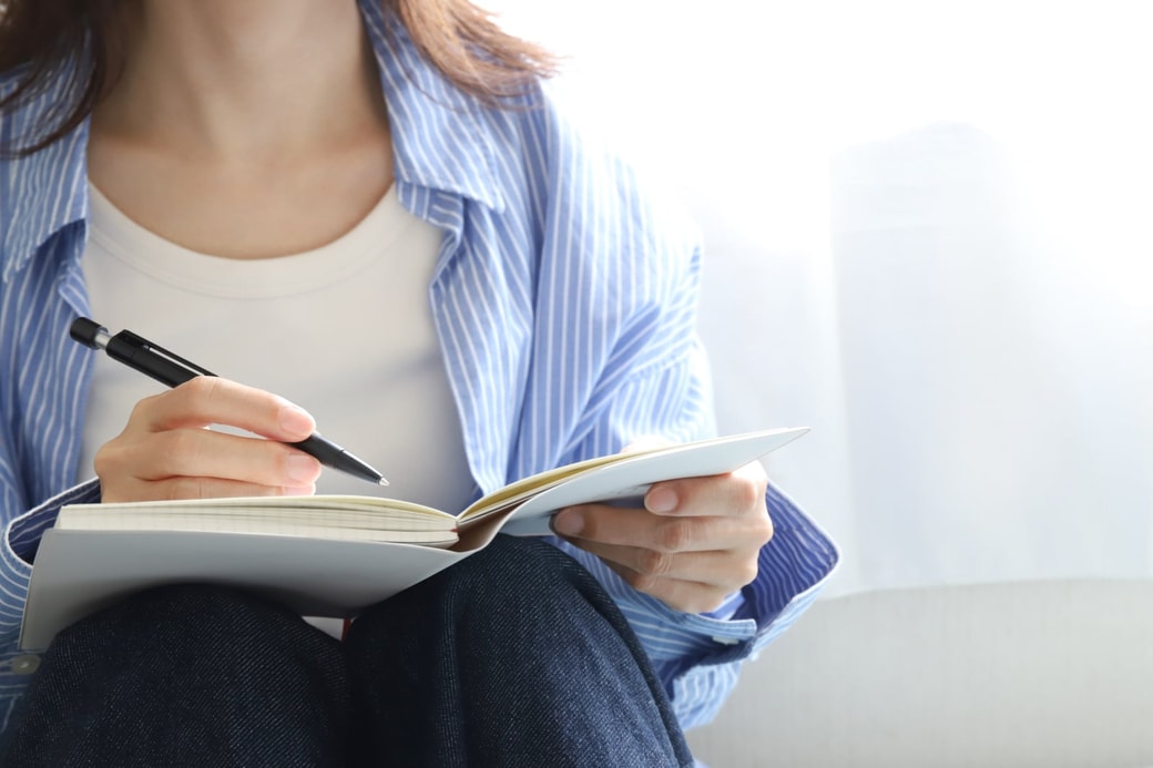 手帳とペンを持った女性
