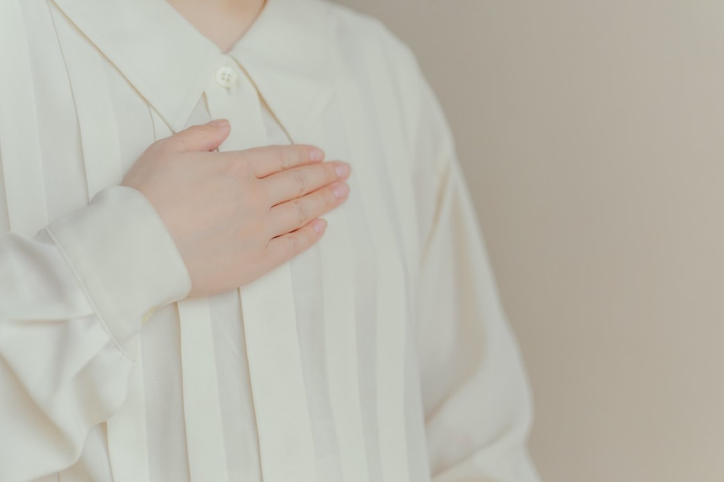 胸に手を当てる女性