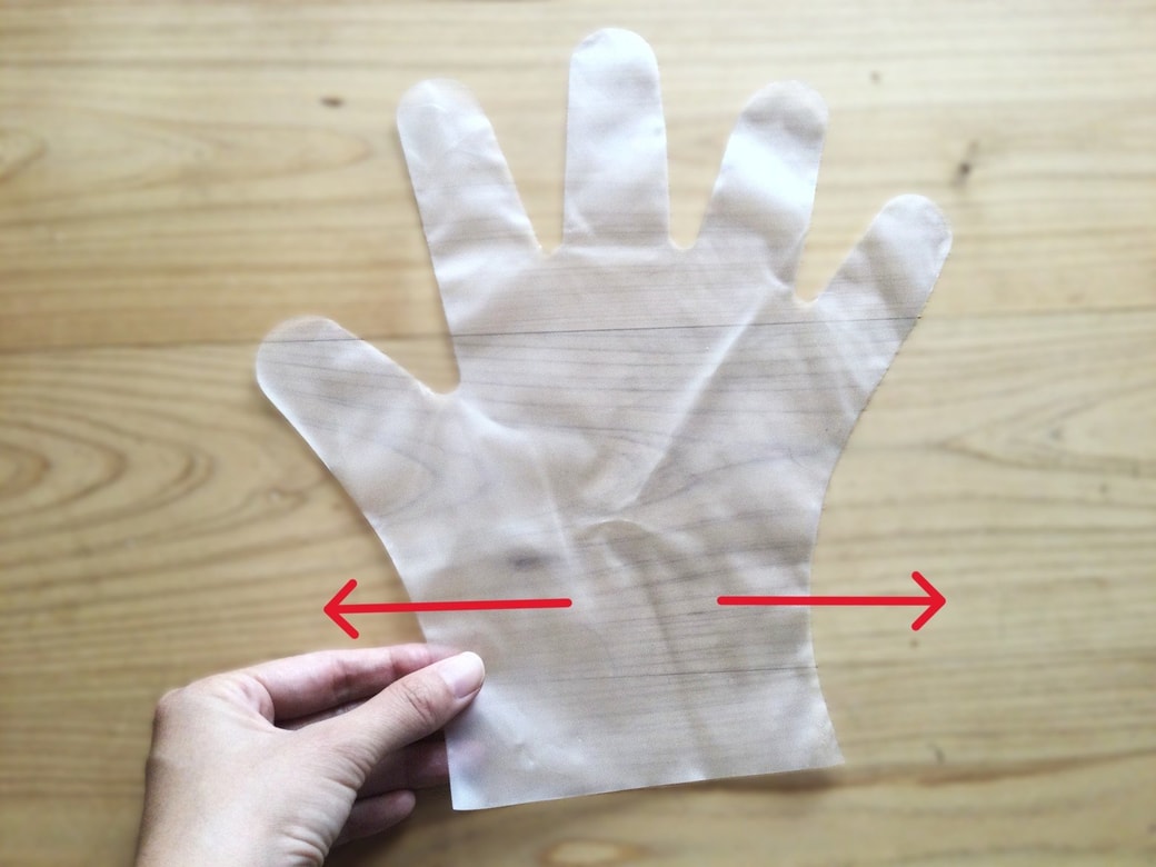 ビニール手袋の手首部分を引っ張る