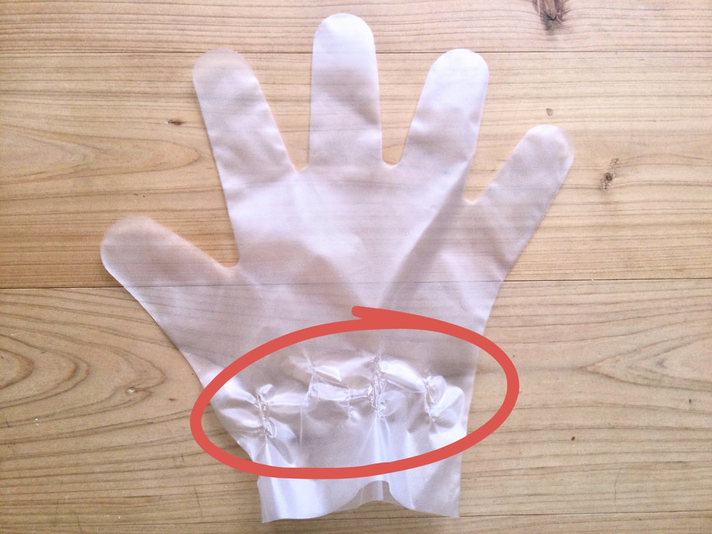 ビニール手袋の手首部分を引っ張る