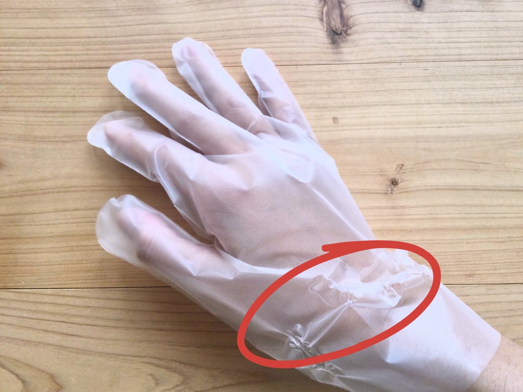 ビニール手袋の手首部分を引っ張る