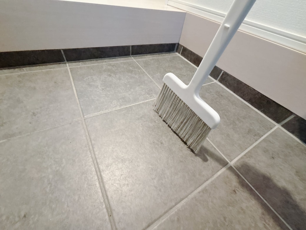 ほうきで砂などの汚れをとる