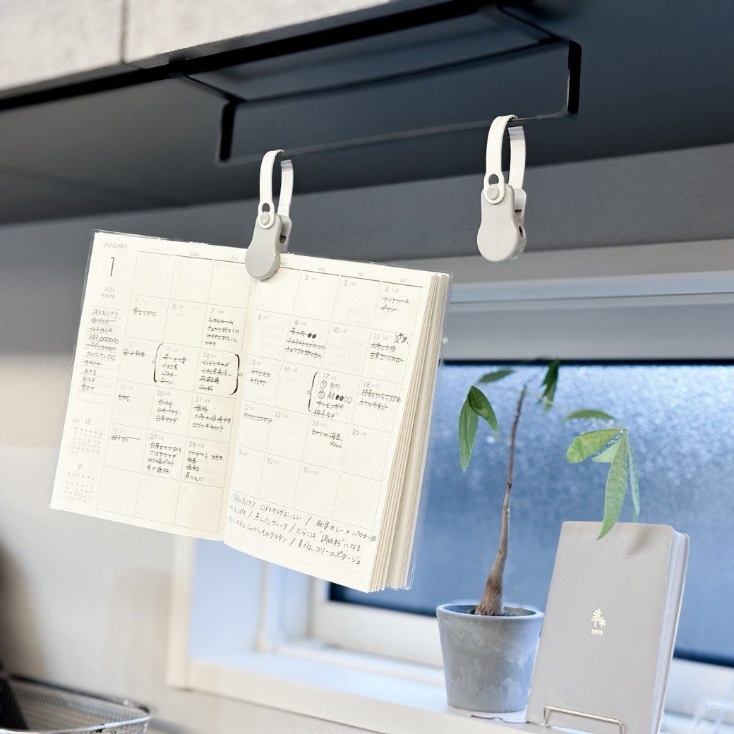 マルチタオルクリップを使って空中に吊り下げられた薄型手帳