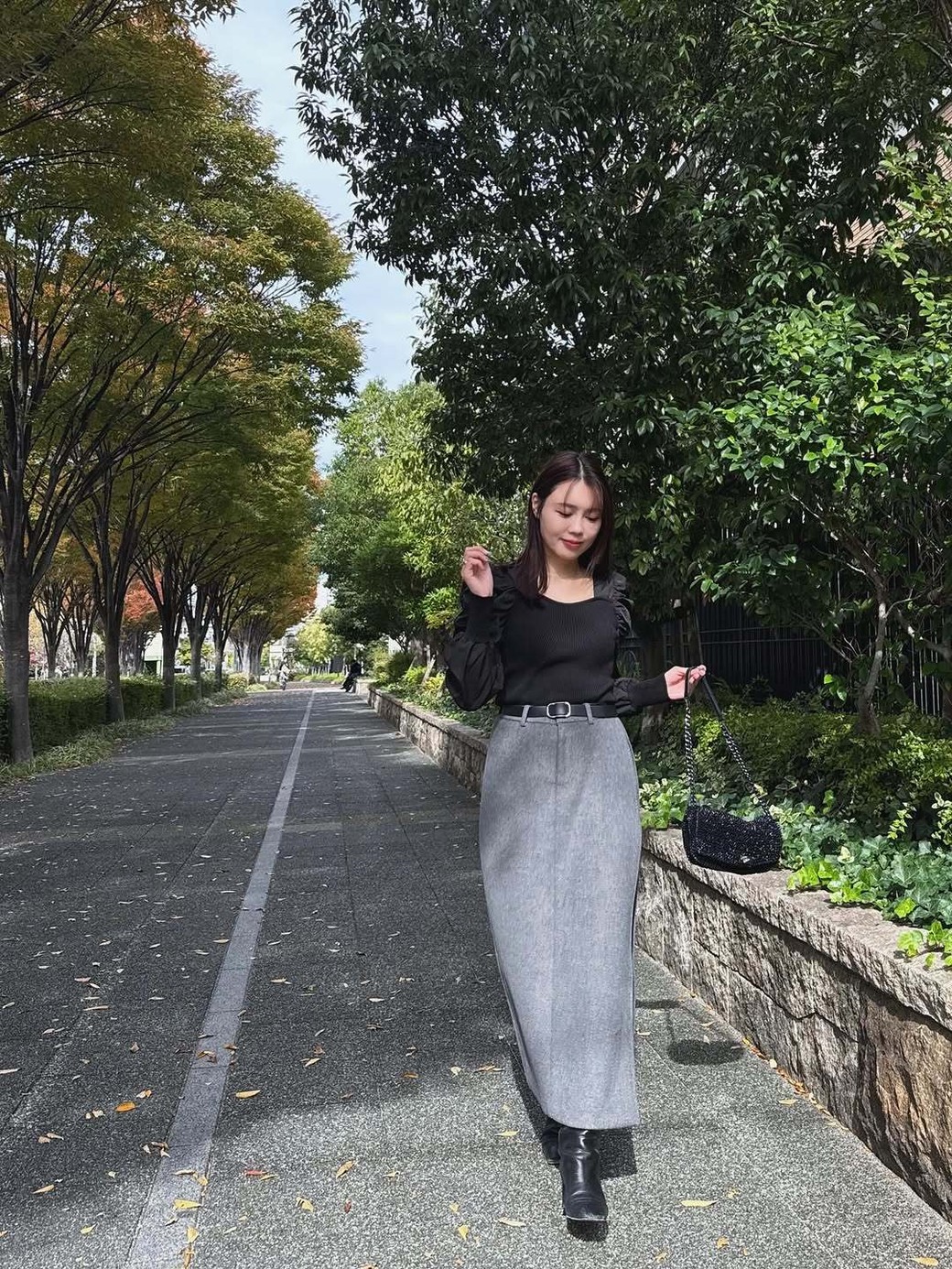 サイドのスリットからロングブーツを見せる、計算されたコーデが◎。