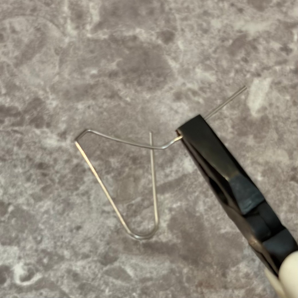 ペンチを使ってクリップを曲げているところ