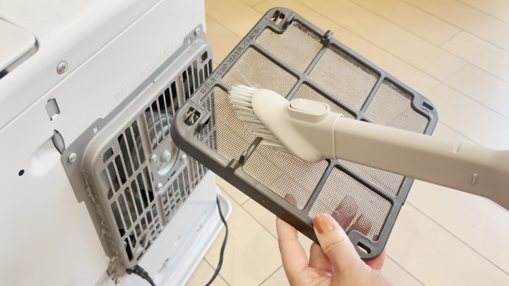 掃除機でフィルターのホコリを吸い取る