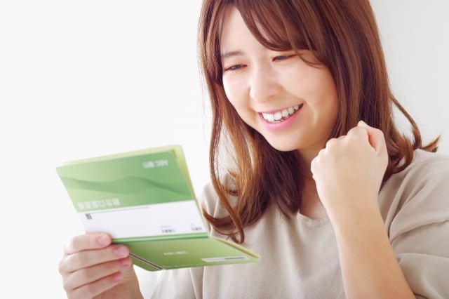 うれしそうに通帳を見る女性