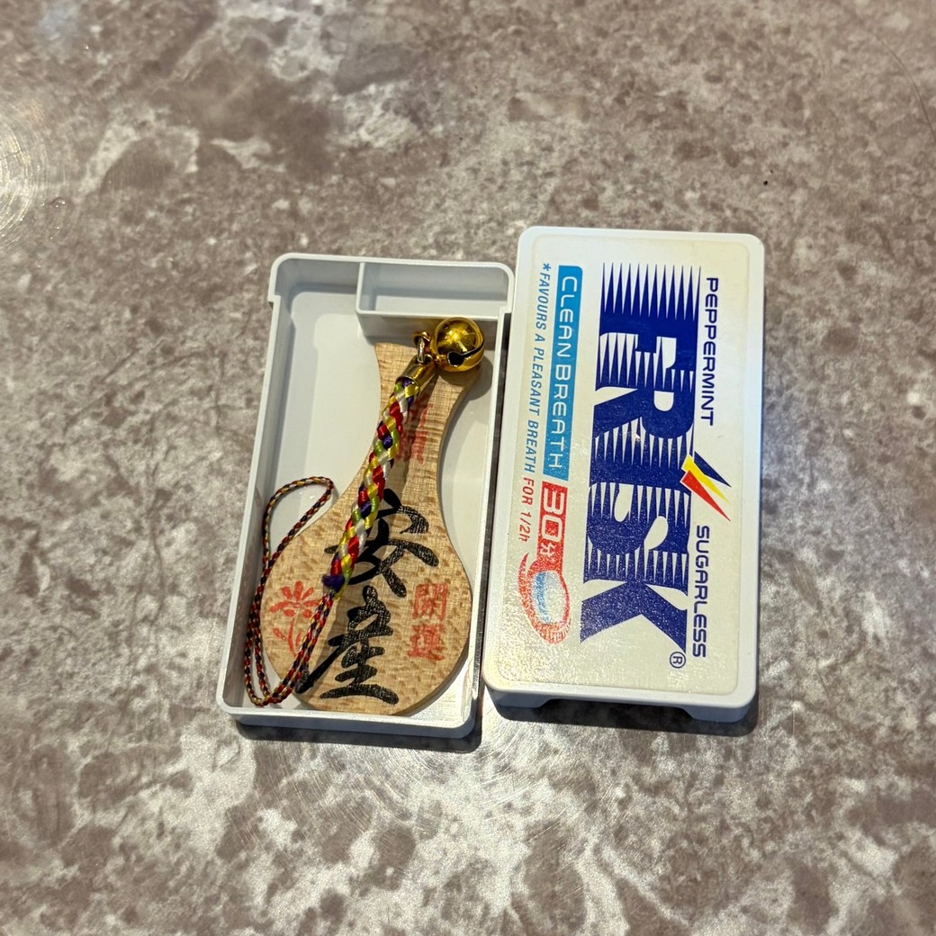 フリスクの容器にお守りを入れているところ