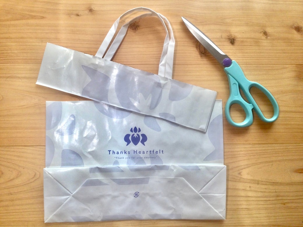 紙袋をハサミで切る