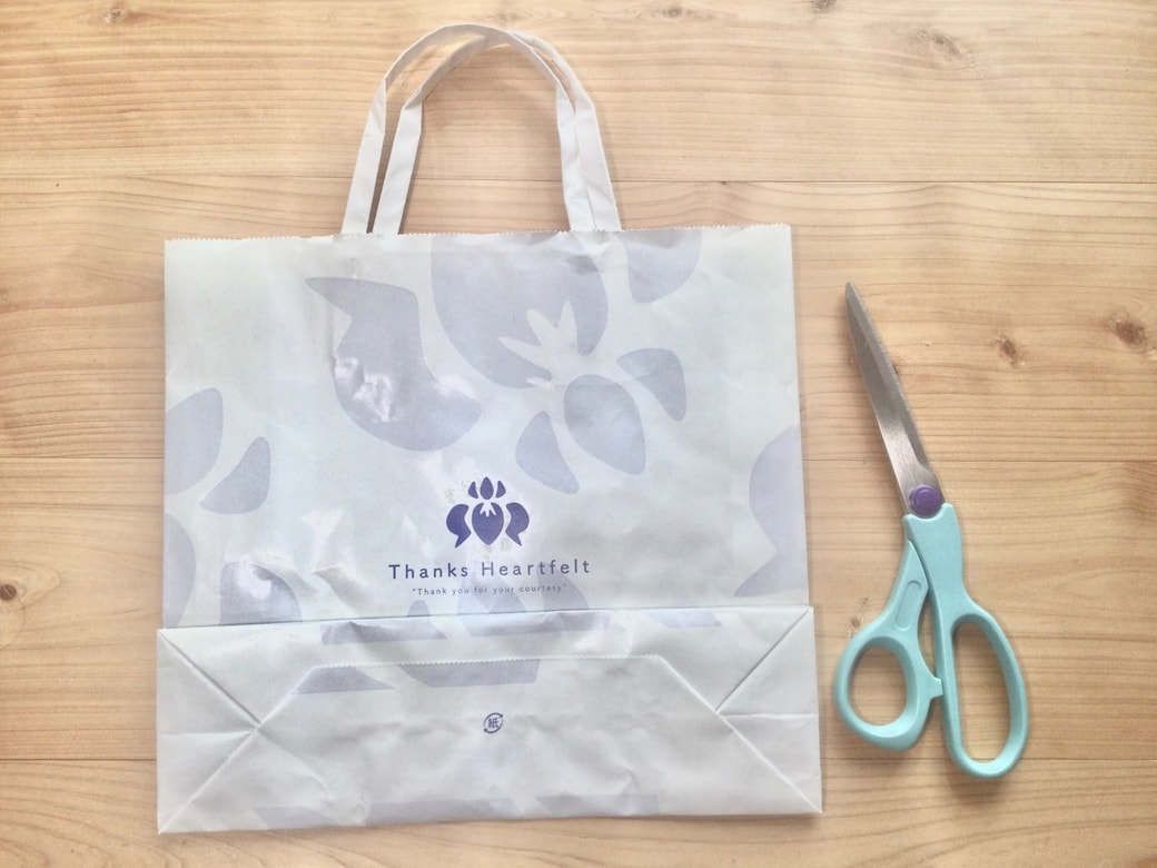 紙袋をハサミで切る