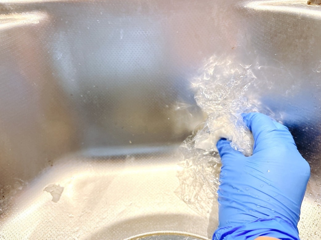 丸めたラップで黒カビ汚れをこする