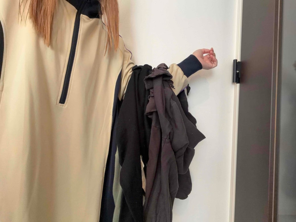 洋服を腕にたくさんかけているところ