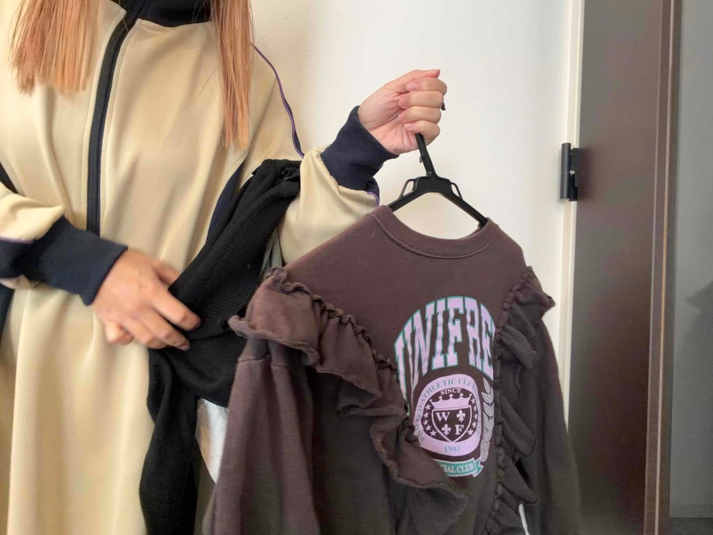 洋服にハンガーをかけているところ