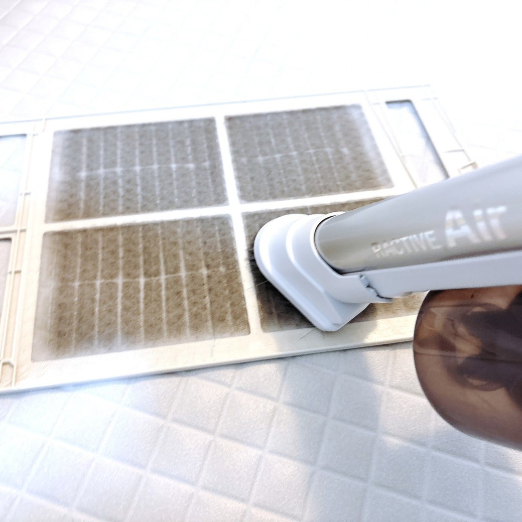 掃除機でホコリを吸い取る