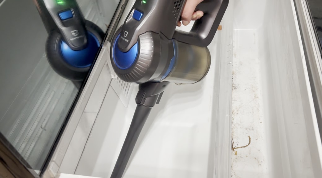 野菜室の中のゴミを掃除機で吸い取る