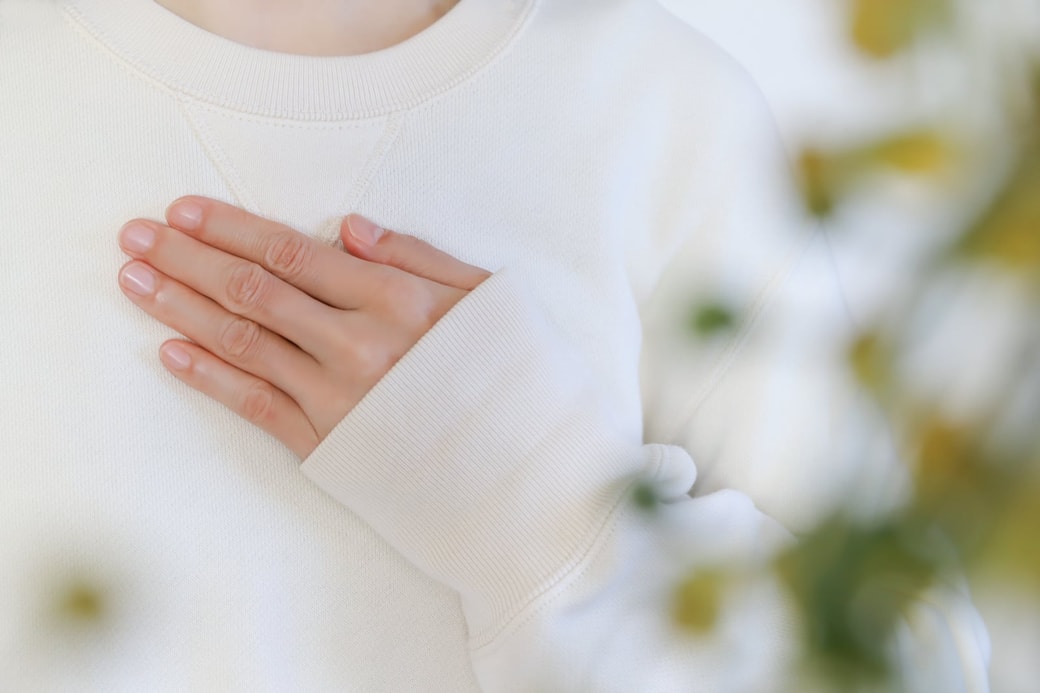 胸に手を当てる女性