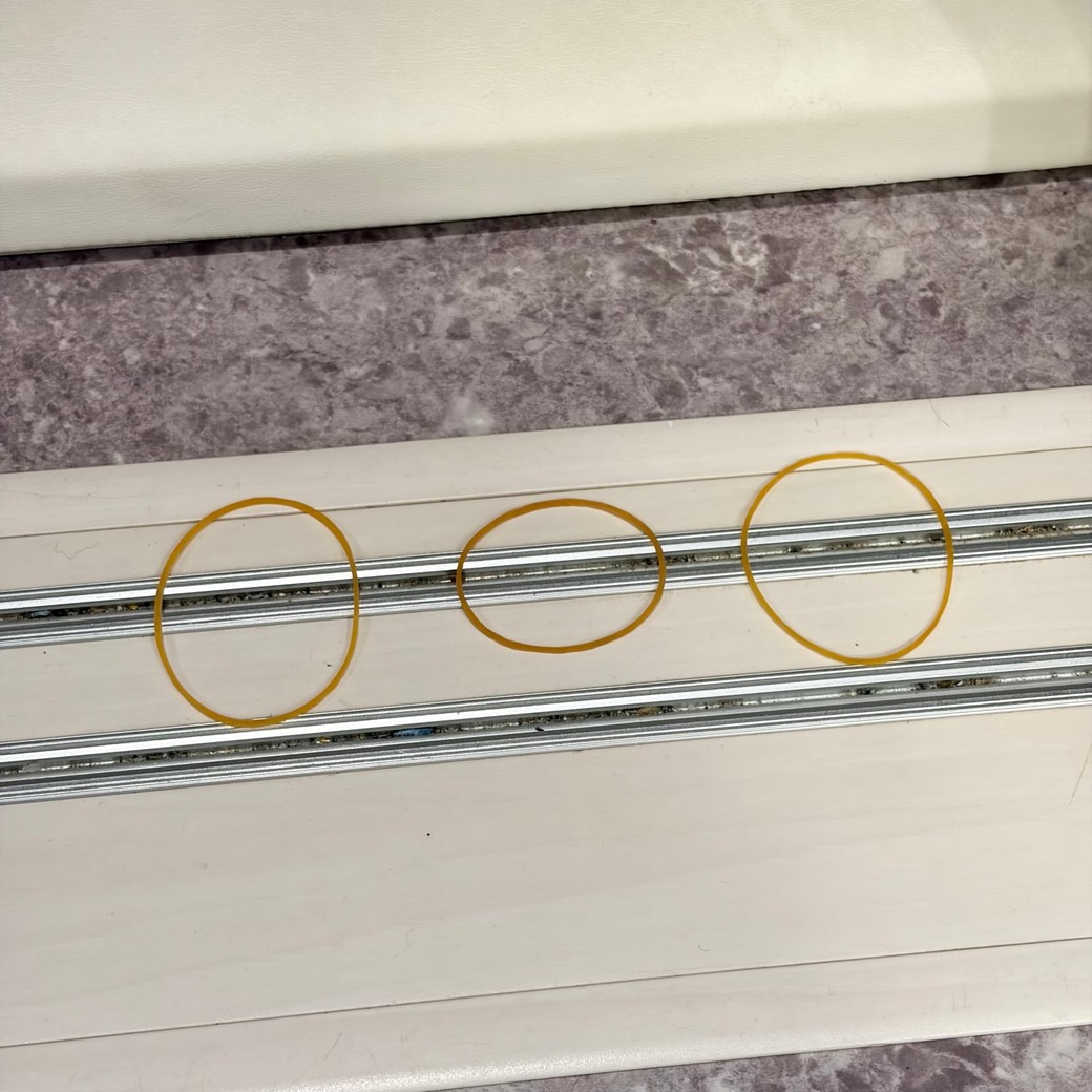 ドアレールの上に輪ゴムを置いているところ