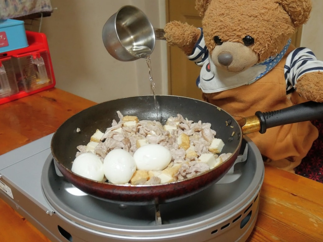 調味料を加えるくまくん