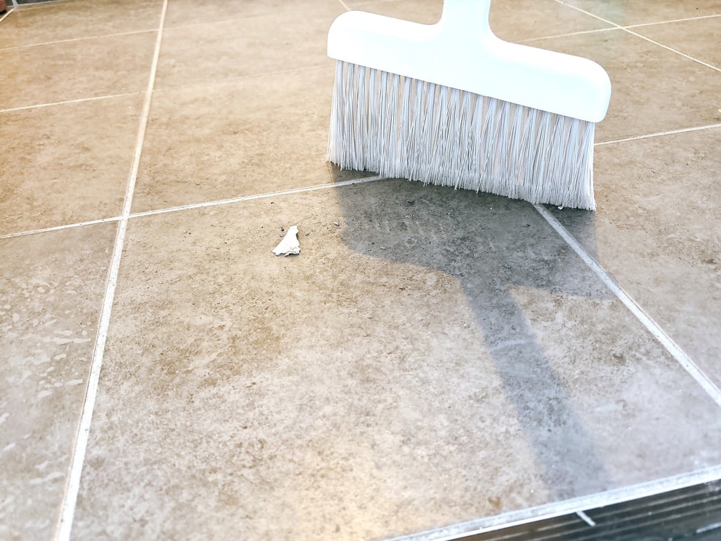 ほうきでゴミを集めて取り除く