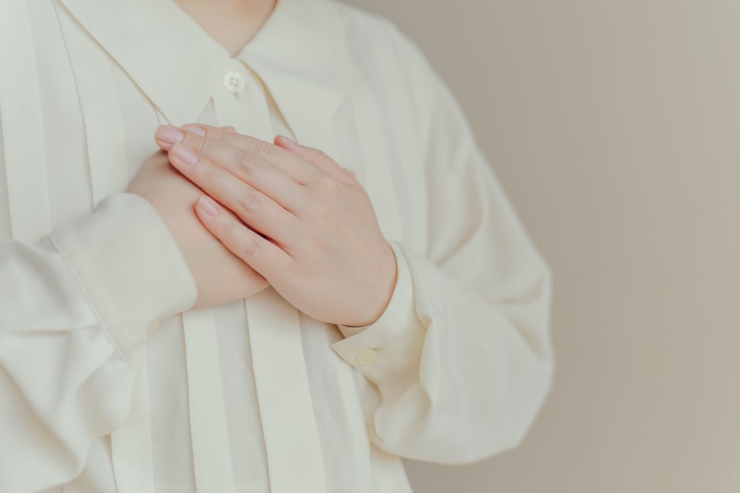 胸に手を当てる女性