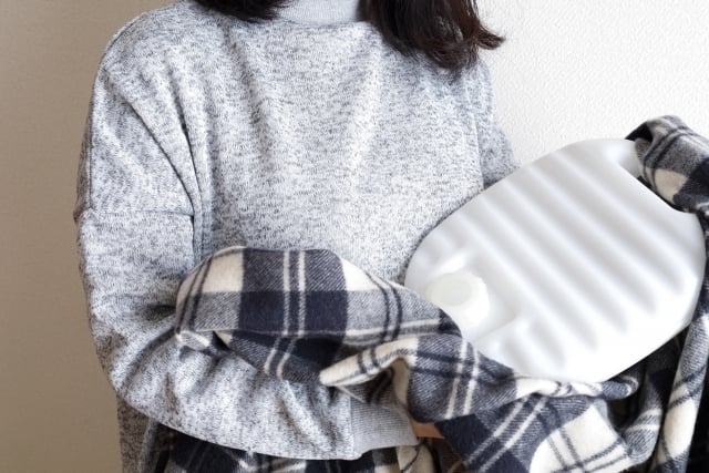 湯たんぽで温まる女性