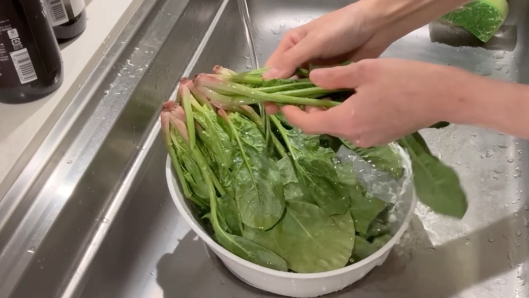 ほうれん草を水で洗う人