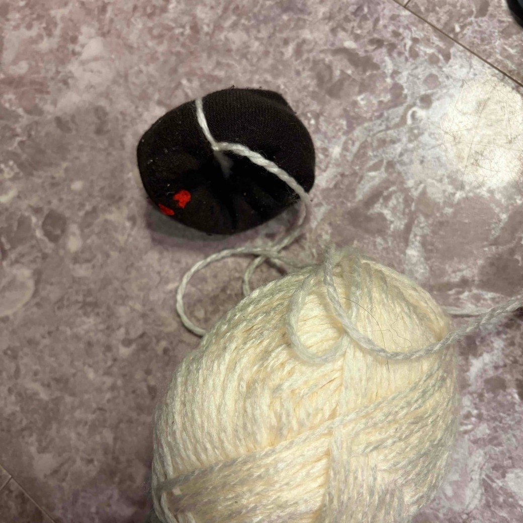 ドーナツ型の靴下に毛糸を巻き付けているところ