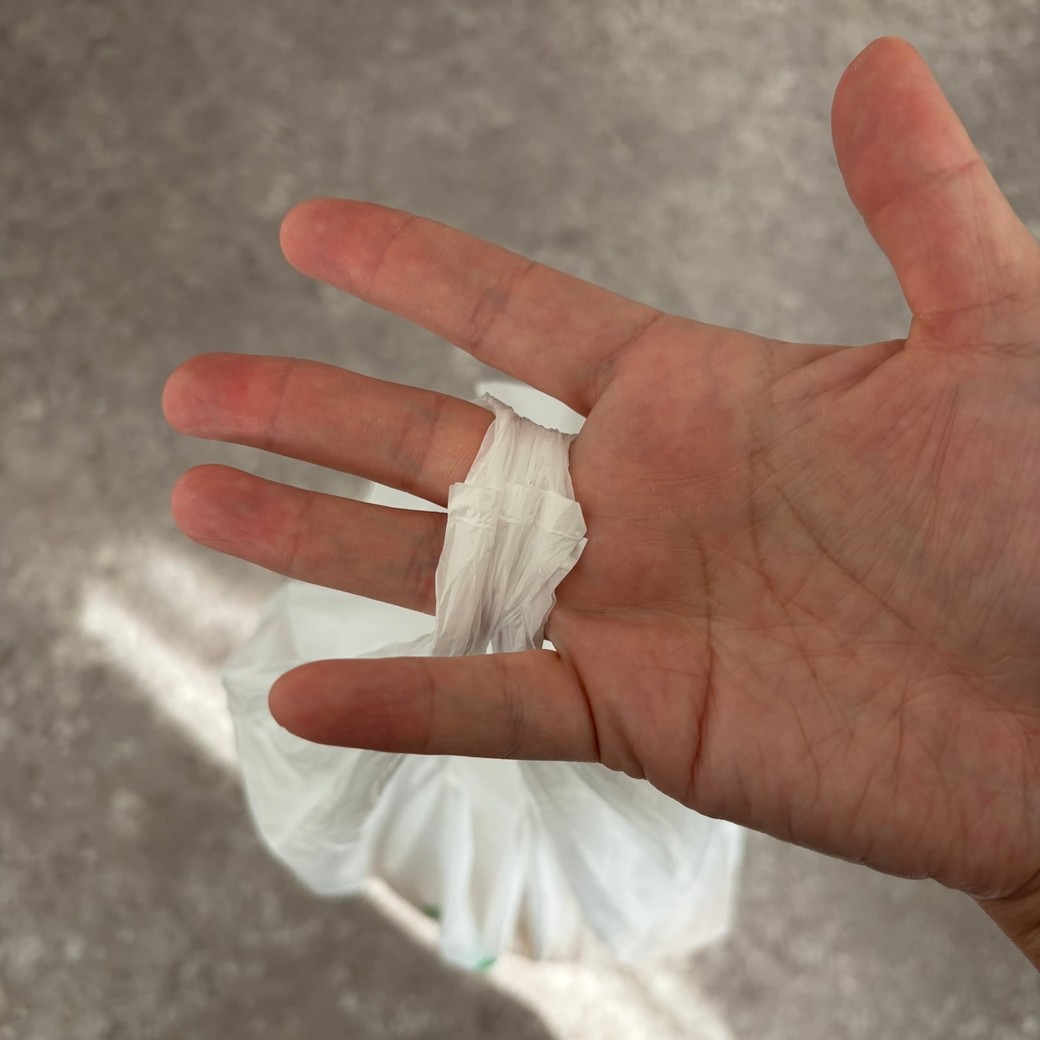 中指と薬指で買い物袋を持っているところ