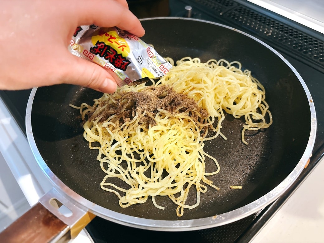 フライパンで焼きそば麺を炒め、ソースで味を付ける