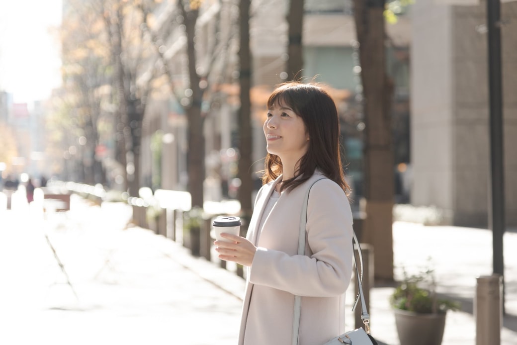 街でコーヒーを飲む女性