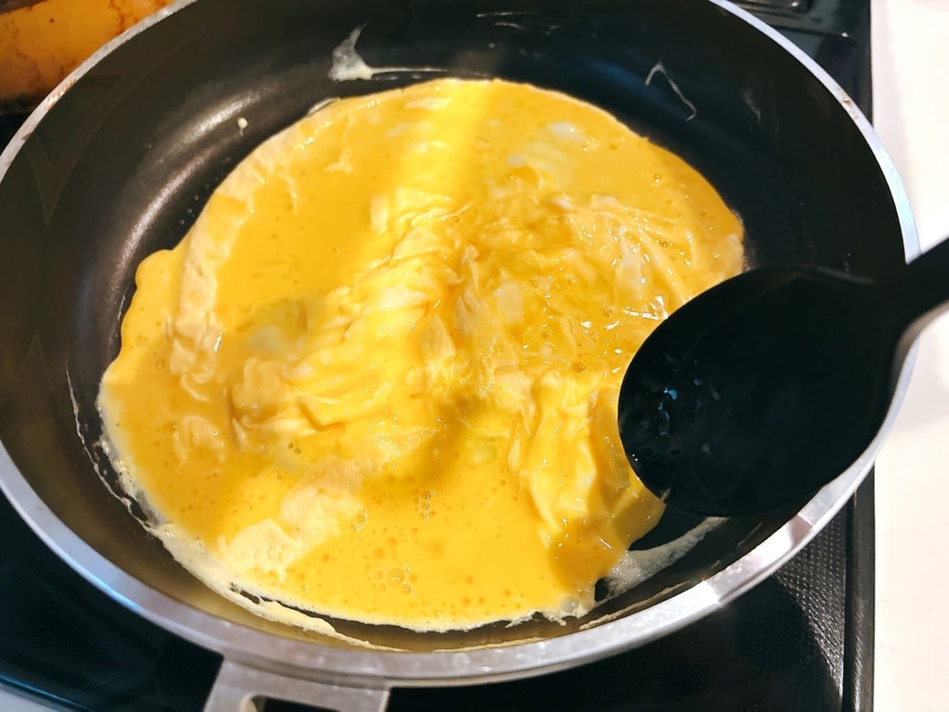 ふちが固まってきたらヘラで大きく混ぜる