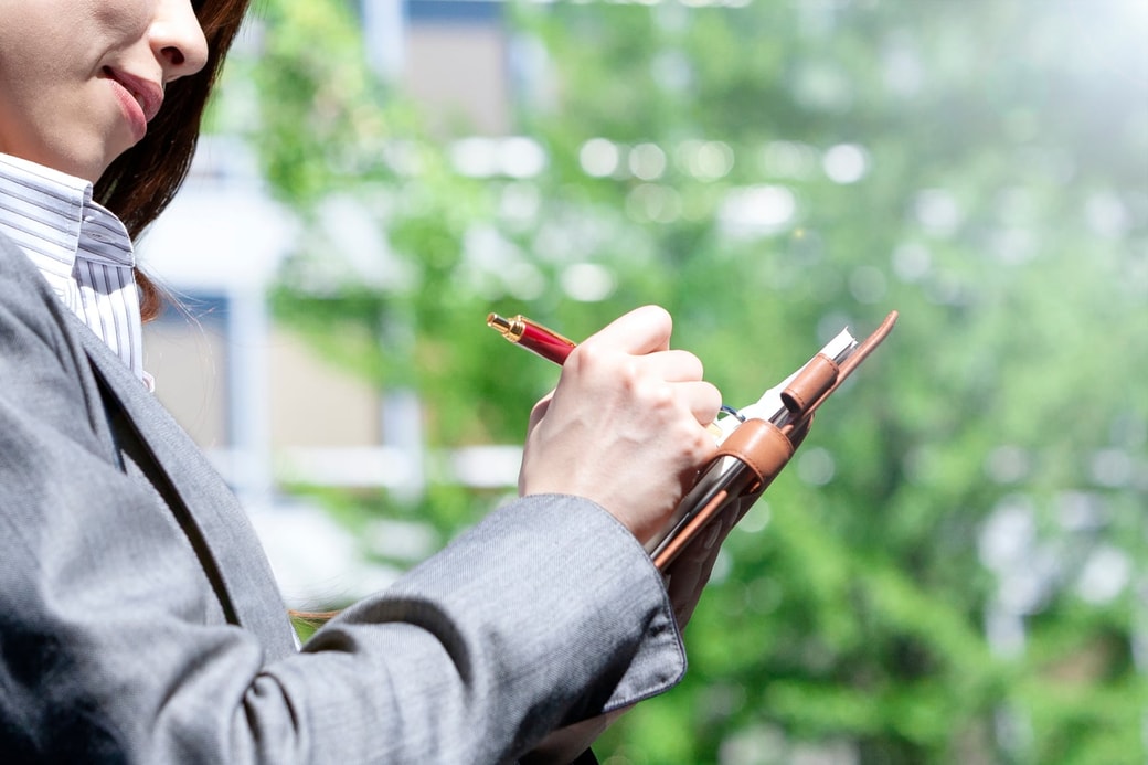 スケジュール帳にメモする女性